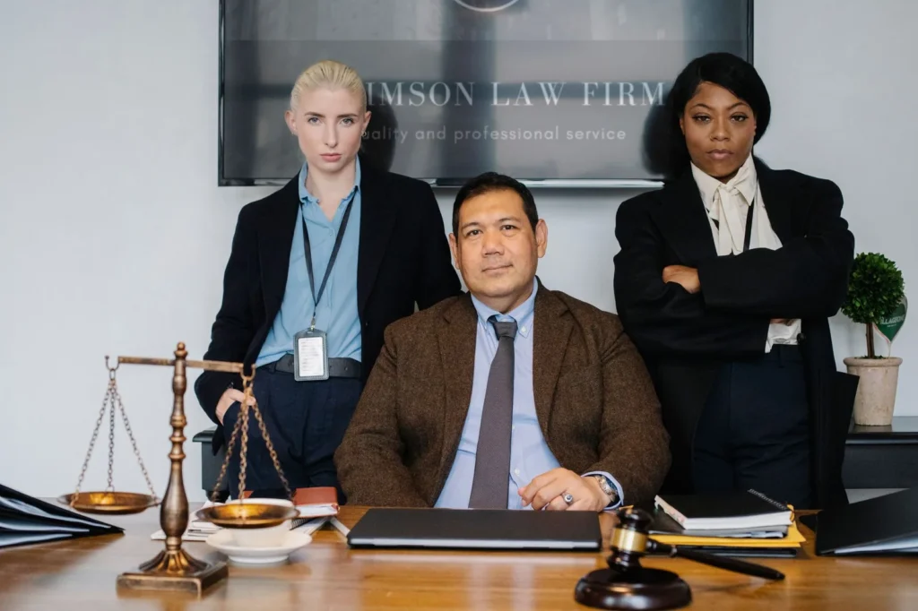 Grupo de legisladores bem-sucedidos posando ao lado de uma mesa com balanças da justiça, simbolizando SEO advocacia