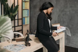 Mulher profissional em terno revisa documentos legais em sua mesa de escritório, representando landing pages para