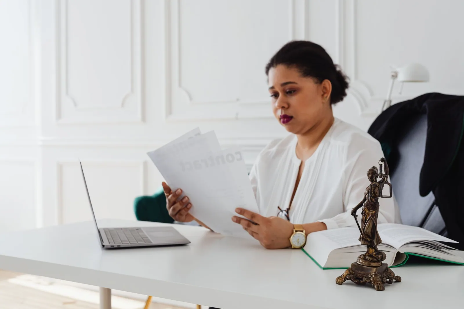 Advogada negra analisando papéis legais em um ambiente de escritório moderno, destacando a reputação profissional