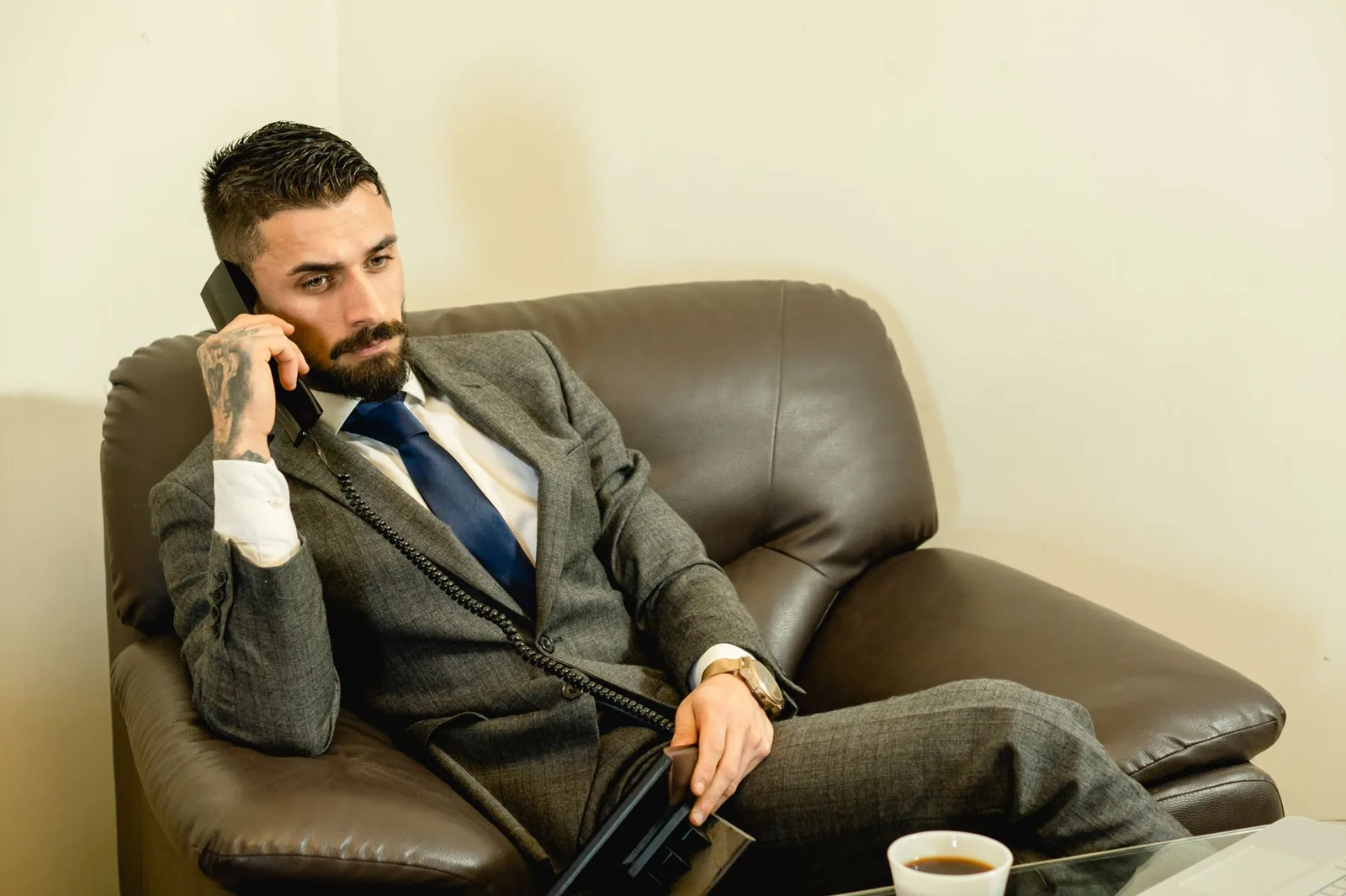 Advogado de terno cinza conversando ao telefone em um escritório moderno, representando o uso do whatsapp para advogados