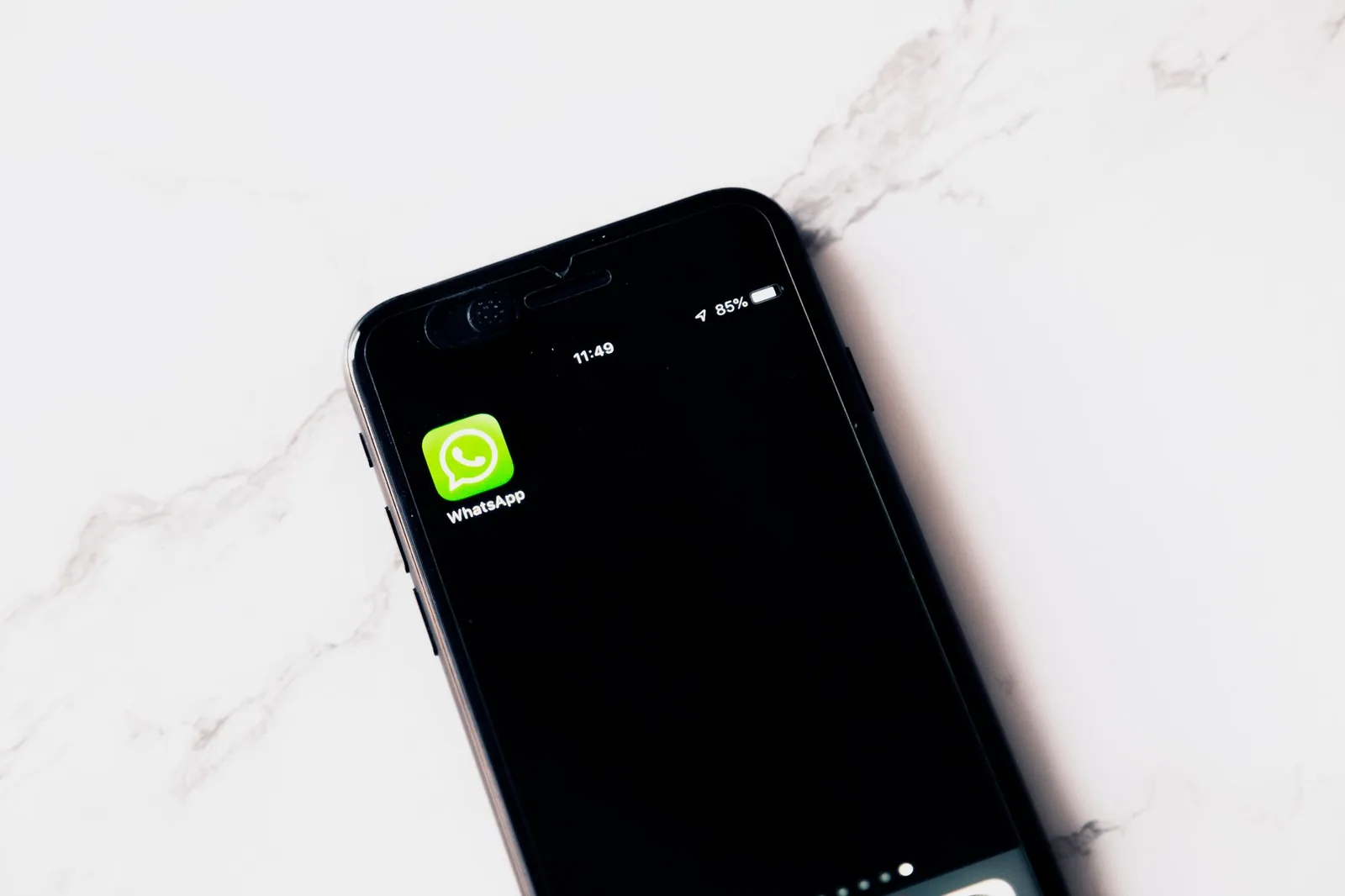 Smartphone com WhatsApp em uma mesa branca, ilustrando a configuração do perfil do WhatsApp Business