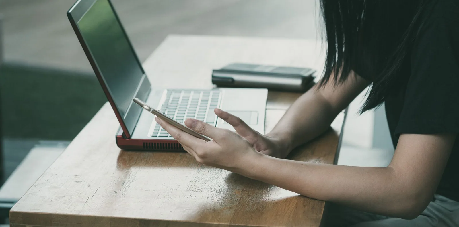 Advogada multitarefas com celular e notebook durante o planejamento de campanhas de email advogado